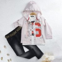 L'ensemble 2244 est composé d'une chemise à capuche rayée avec NEW YORK et un S rouge, d'un T-shirt blanc et d'un jean foncé avec une ceinture en pied-de-poule, le tout présenté à plat sur une surface blanche texturée.